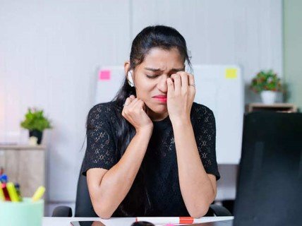 Picture of a  stressed woman at work sitting at her desk